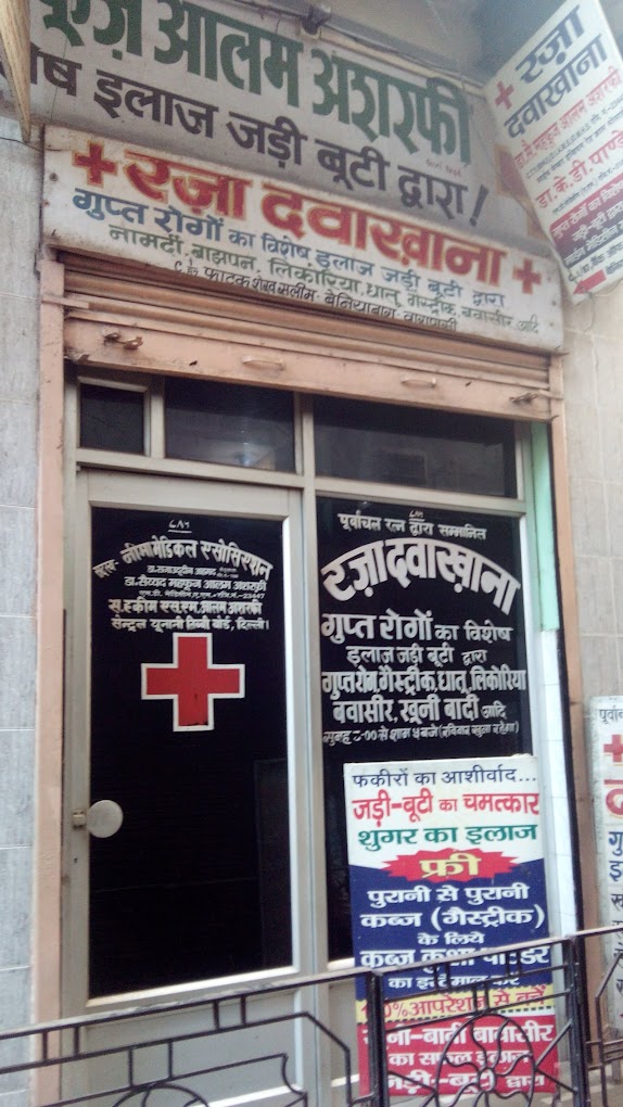 A storefront with various signs in Hindi, featuring a medical cross symbolizing a pharmacy or clinic.