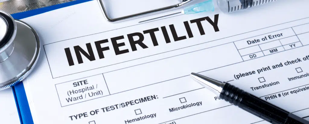 Medical form titled "INFERTILITY" with pen and stethoscope on top.